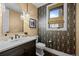 Stylish powder room featuring patterned wallpaper, a decorative mirror, and a modern vanity at 7912 Raphael Ln, Littleton, CO 80125