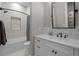 Modern bathroom featuring a sleek vanity, a shower-tub combo, and stylish tile work at 7912 Raphael Ln, Littleton, CO 80125