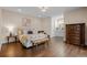 Inviting bedroom with hardwood floors, a decorative bed, and an adjacent bathroom at 7912 Raphael Ln, Littleton, CO 80125
