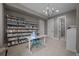 Bright craft room with shelving for storage, a white table, and a chandelier at 7912 Raphael Ln, Littleton, CO 80125