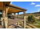Elevated outdoor deck with wood ceiling and stone columns overlooking the golf course at 7912 Raphael Ln, Littleton, CO 80125