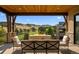 Outdoor deck seating area with fire pit overlooking a golf course and rolling hills at 7912 Raphael Ln, Littleton, CO 80125