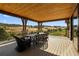 Covered deck with dining set, wood ceiling, and golf course views at 7912 Raphael Ln, Littleton, CO 80125