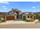 Stunning stone and stucco home with a charming courtyard, wooden garage doors and lush landscaping at 7912 Raphael Ln, Littleton, CO 80125