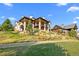 Beautiful home exterior with stone accents, covered decks, and landscaped yard at 7912 Raphael Ln, Littleton, CO 80125