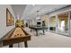 Entertaining game room with shuffleboard, pool table, and sliding doors to a patio at 7912 Raphael Ln, Littleton, CO 80125