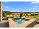 Stone hot tub overlooking golf course, grassy hills and scattered foliage at 7912 Raphael Ln, Littleton, CO 80125
