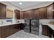 Large laundry room with dark cabinetry, patterned floors, utility sink, and modern washer dryer at 7912 Raphael Ln, Littleton, CO 80125