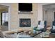 Comfortable living room features a stone fireplace with tv and slider door to outdoor deck at 7912 Raphael Ln, Littleton, CO 80125
