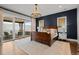 Main bedroom with chandelier, dark accent wall and sliding door access to balcony with view at 7912 Raphael Ln, Littleton, CO 80125