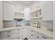 Walk-in pantry with white cabinetry, quartz counters and decor shelving at 7912 Raphael Ln, Littleton, CO 80125