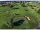Beautiful aerial view of a well-manicured golf course with lush green fairways, sand traps, and mature trees at 8225 Fairmount Dr # 106, Denver, CO 80247