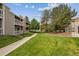 Well-manicured backyard with lush lawn and mature trees perfect for outdoor enjoyment at 8225 Fairmount Dr # 106, Denver, CO 80247