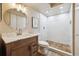 Modern bathroom with tiled shower, updated vanity, shelving and contemporary fixtures at 8225 Fairmount Dr # 106, Denver, CO 80247