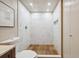 Tiled shower with rainfall shower-head, built-in niche, and wood style floor insert at 8225 Fairmount Dr # 106, Denver, CO 80247