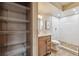 Bathroom with storage shelves, marbled tile shower with rainfall showerhead, and modern vanity at 8225 Fairmount Dr # 106, Denver, CO 80247