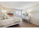 Bright bedroom featuring light walls, wood floors, a white bed frame and updated windows at 8225 Fairmount Dr # 106, Denver, CO 80247