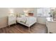 Bright bedroom featuring light walls, wood floors, a white bed frame and updated windows at 8225 Fairmount Dr # 106, Denver, CO 80247