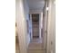 Hallway with an open door to the closet, featuring light wood floors and shelving at 8225 Fairmount Dr # 106, Denver, CO 80247