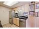 Efficient kitchen featuring stainless steel appliances, granite countertops, mosaic backsplash, and light wood cabinets at 8225 Fairmount Dr # 106, Denver, CO 80247