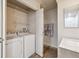 Well-lit laundry room featuring modern appliances, shelving, and ample storage space at 8225 Fairmount Dr # 106, Denver, CO 80247