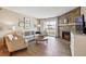 Bright living room with stone fireplace, comfortable seating, and sliding glass doors leading to a balcony at 8225 Fairmount Dr # 106, Denver, CO 80247