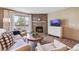 Comfortable living room with a stone fireplace, sliding glass doors to deck, and neutral-toned furniture at 8225 Fairmount Dr # 106, Denver, CO 80247