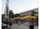 Vibrant outdoor seating area with umbrellas and rocket statue, creating a lively gathering spot for locals at 8225 Fairmount Dr # 106, Denver, CO 80247