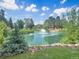 Picturesque pond with a fountain, surrounded by lush greenery and mature trees at 8225 Fairmount Dr # 106, Denver, CO 80247