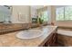 Bathroom with double sinks with stone counters and cabinets with a large mirror at 10064 Bluffmont Ct, Lone Tree, CO 80124