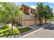 Beautiful townhome featuring a stone facade, attached garages, and an upper balcony overlooking the well-maintained street at 10064 Bluffmont Ct, Lone Tree, CO 80124