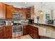 A kitchen featuring granite counters, stainless steel appliances, and dark wood cabinetry at 10064 Bluffmont Ct, Lone Tree, CO 80124