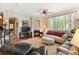 Cozy living room featuring a fireplace, large window, ceiling fan, and comfortable seating arrangements at 10064 Bluffmont Ct, Lone Tree, CO 80124