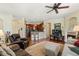 Open living room features hardwood floors, ceiling fan, fireplace, and seamless flow into the kitchen at 10064 Bluffmont Ct, Lone Tree, CO 80124