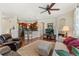 Open living room features hardwood floors, ceiling fan, fireplace, and seamless flow into the kitchen at 10064 Bluffmont Ct, Lone Tree, CO 80124