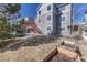 The backyard showcases a lawn, and a red staircase leading to the deck above, set against a backdrop of a blue sky at 15972 E Tall Timber Ln, Parker, CO 80134