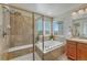 Elegant bathroom featuring a walk-in shower and separate soaking tub under natural light at 15972 E Tall Timber Ln, Parker, CO 80134