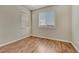 Cozy bedroom with wood floors, two windows, and neutral paint at 15972 E Tall Timber Ln, Parker, CO 80134