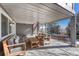 Inviting covered patio with comfortable seating, ideal for outdoor relaxation and entertaining, with views of the yard at 15972 E Tall Timber Ln, Parker, CO 80134