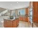 Bright kitchen with tile flooring, stainless appliances, and an island cooktop at 15972 E Tall Timber Ln, Parker, CO 80134