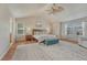 Vaulted main bedroom featuring a ceiling fan, ensuite bathroom, and bright windows at 15972 E Tall Timber Ln, Parker, CO 80134