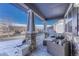 Relaxing front porch with comfortable wicker seating and stone columns at 15972 E Tall Timber Ln, Parker, CO 80134