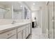 Well-lit bathroom featuring dual vanities, modern fixtures, and a separate shower and bathtub for convenience at 4976 S Nelson St # A, Littleton, CO 80127