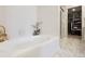 Clean bathroom featuring a tub with tile surround, shower, and doorway to closet at 4976 S Nelson St # A, Littleton, CO 80127