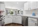 Bright kitchen featuring white cabinets, stainless steel appliances, quartz countertops, and modern finishes at 4976 S Nelson St # A, Littleton, CO 80127