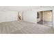 Spacious carpeted basement featuring multiple closets, stairs, and a sliding glass door at 8270 S High Ct, Centennial, CO 80122
