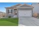 Gray exterior ranch home with white garage door, landscaping, and a short driveway at 1152 Payton Ave, Fort Lupton, CO 80621