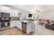 Open concept kitchen with island, stainless steel appliances, and white cabinets at 1152 Payton Ave, Fort Lupton, CO 80621