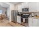 Modern kitchen with stainless steel appliances and white cabinets at 1152 Payton Ave, Fort Lupton, CO 80621