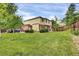 Expansive backyard with lush lawn, mature trees, and partial fence, perfect for outdoor activities at 3109 S Jebel Way, Aurora, CO 80013